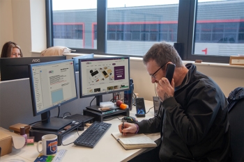 Tristan on the phone at his desk